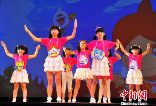 图为日本同源中文学校的学生们登台助兴，表演卡通歌舞。　王健 摄