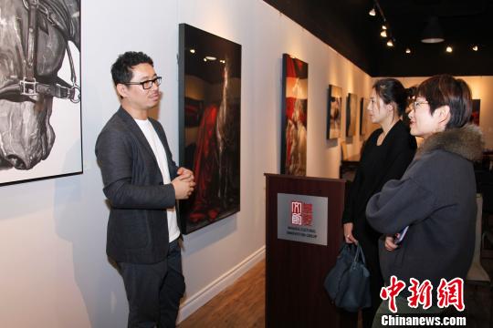 图为孙浩(左一)在展厅与观众交流。　余瑞冬 摄