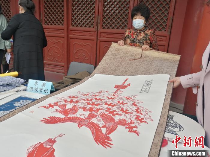 非物质文化遗产传承人在展览上展示其剪纸作品。　李晛 摄